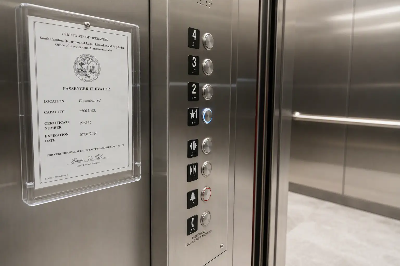 ADA-compliant hospital elevator control panel with South Carolina certificate of operation posted inside the cab, illustrating healthcare elevator compliance requirements.